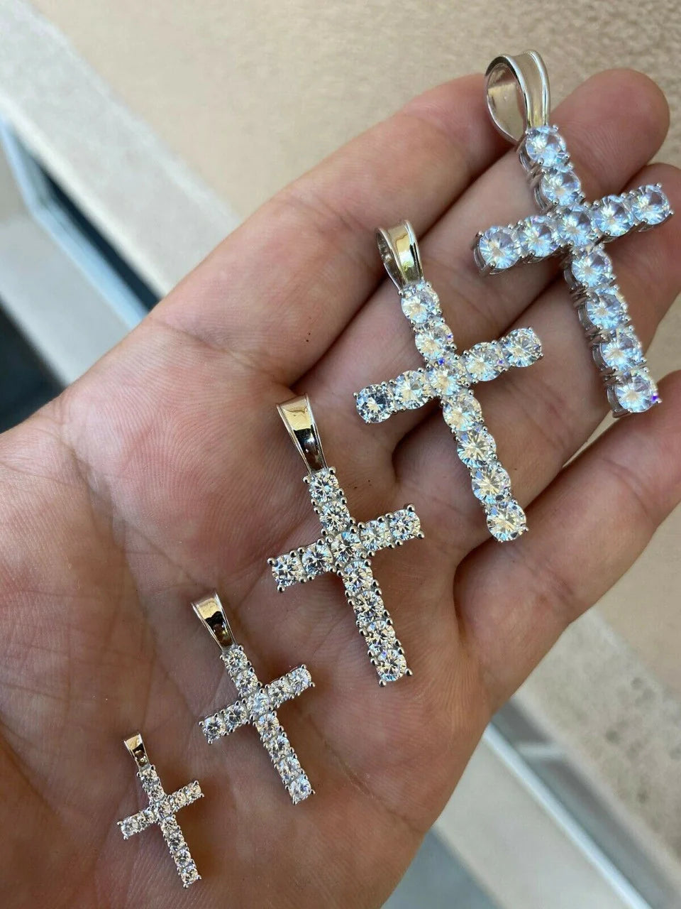 Detailed view of iced out Jesus cross pendants in multiple sizes